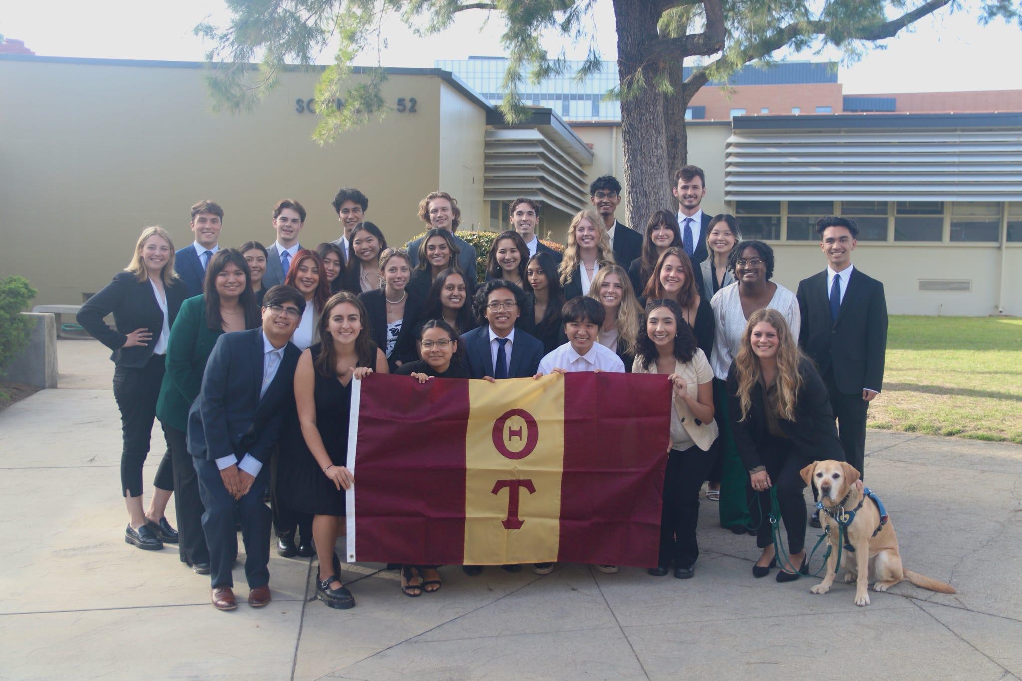 Theta Tau members gathered with the chapter flag